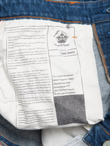 Close-up of the inside label of a pair of blue jeans, showing detailed printed text and branding information on a white fabric patch. The label features the Blue de Gênes logo and product details for their Vinci Topaz Vintage Jeans – Used, highlighting these regular fit jeans crafted from comfort stretch denim and proudly made in Italy.