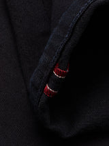Close-up of the cuff of the Vinci Venom Blk Jeans - Dark Denim by Blue de Gênes, showing red and white stitching along the edge. The fabric texture and detailed threads are clearly visible, highlighting the premium comfort stretch twill used in these regular fit jeans.