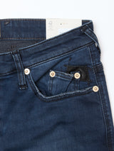 Close-up of Blue de Gênes Repi BlueBlk Used Jeans in blue black denim, showing the front and coin pocket, waistband with metal rivets, and a partially visible white tag.