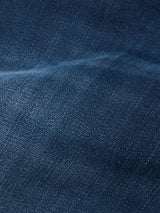 Close-up of Repi BlueBlk Used Jeans by Blue de Gênes in blue-black denim, highlighting the comfort stretch fabric's textured weave, subtle color shifts, and depth from light and shadow across its durable material.