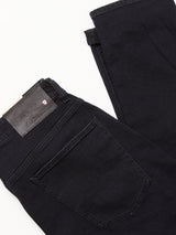 A pair of folded Recco BlueBlk Jeans by Blue de Gênes in blue-black denim, displayed on a white background, with visible back pocket, waistband, and branded black leather patch near the belt loop.