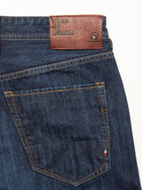 Close-up of the back pocket of the Giacomo Dark Horse Jeans in denim blue, featuring rigid dark blue denim and a brown leather Blue de Gênes patch stitched near the waistband. These relaxed loose fit jeans are expertly crafted in Italy, reflecting premium craftsmanship and meticulous attention to detail.