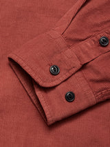 A close-up of the Zamboni Velu Shirt - Henna by Blue de Gênes highlights the rich corduroy texture, detailed stitching, and two black cuff buttons—all hallmarks of this garment-dyed piece.