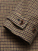 Close-up of the Massone Check Coat - Multi Check by Blue de Gênes, showing a fabric sleeve in brown and beige houndstooth with two dark brown cuff buttons.