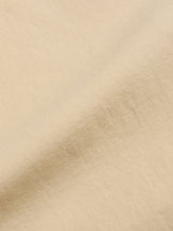 A close-up of the soft, pale khaki fabric of the BGpalco Rodas Pants by Blue de Gênes, with gentle folds and subtle shadows—an ideal choice for crafting smart-casual looks.