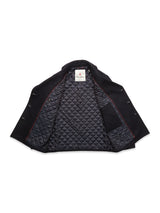 The Shiba Melton Coat in Dark Navy by Blue de Gênes is laid open, revealing its quilted inner lining with diamond stitching, a single interior pocket, and a visible neck label—a testament to the brand’s fine Portuguese craftsmanship.