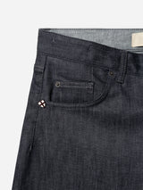 BGleroy Jeans - Raw Denim by Blue de Gênes, shown in a close-up of the waistband and front pocket area, featuring a small decorative patch on the coin pocket. These five-pocket jeans are crafted with innovative raw denim construction for enhanced durability and style. Set against a white background.