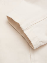 Close-up of the cuff from the BGbaio Twill Blazer in Chalk by Blue de Gênes, crafted from textured cotton twill fabric. The light beige cuff is neatly folded and stitched, lying flat against the matching material—echoing the refined details found in classic tailoring.