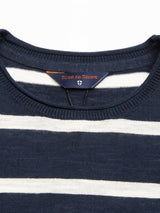 Close-up of the Monte Stripe Knit - Navy sweater by Blue de Gênes, featuring navy and white stripes and a brand label stitched inside the collar.