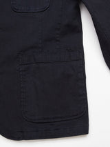 Close-up of the Blue de Gênes Gabbiano Dobby Blazer in dark navy, showing a large front pocket and part of a sleeve, displayed against a white background.