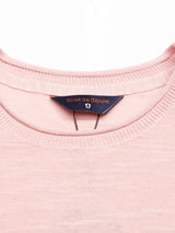 Close-up of the Monte Knit in Porcelain Pink by Blue de Gênes, showing its ribbed collar and a navy tag with Blue de Gênes in orange lettering.