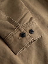 A close-up of the BGcuddy Nebraska Jacket - Brown by Blue de Gênes highlights its brown high-density cotton fabric sleeve with visible stitching and two black buttons on the cuff, exemplifying the durable construction characteristic of quality workwear.