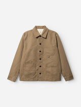 The BGcuddy Nebraska Jacket - Brown by Blue de Gênes is a light brown, long-sleeve workwear jacket crafted from high-density cotton with a subtle dobby weave. It features a button-up front, three front pockets, and a collar, and is shown laid flat on a white background.