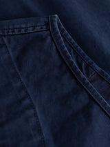Close-up of the BGlumen Nebraska Gilet - Blue by Blue de Gênes, highlighting its high-density cotton vest fabric in a subtle dobby weave. The image showcases the smooth texture, dark stitching, and a distinct pocket or flap detail, emphasizing both durability and refined craftsmanship.