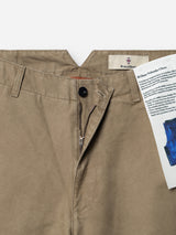 A close-up of the BGliam Nebraska Chino - Brown by Blue de Gênes, crafted from khaki cotton with a button and zipper fly partially unzipped, revealing a label and a folded booklet tucked into the waistband. The subtle dobby weave detail enhances the texture of this classic design.