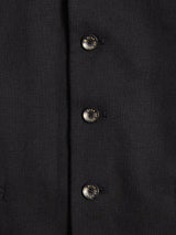 Close-up of the Canna Carbonio Gillet - Black by Blue de Gênes, showcasing three vertically aligned metallic buttons, each engraved with fine text around the edge.