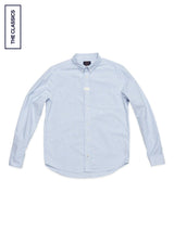The Blue de Gênes BGsandro Oxford Shirt - Blue Stripe, featuring light blue and white vertical stripes with long sleeves, is laid flat on a white background. A small "THE CLASSICS" label appears in the top left corner.
