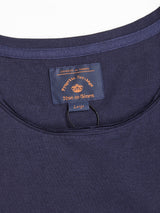 Close-up of the Sagi Nuovo T-shirt in Dark Navy, crafted from premium cotton. The visible label features “Portuguese Heritage” and the Blue de Gênes branding in orange and white text, marked as a size Large. This men’s t-shirt showcases a round neckline, precise stitching, and a regular fit, making it a timeless wardrobe staple.