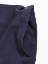 A close-up of dark navy fabric from the Sagi Nuovo T-shirt by Blue de Gênes showcases premium cotton with a neatly stitched seam, slightly wrinkled and set against a white background.
