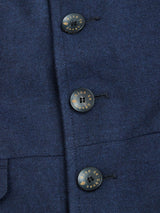 Close-up of the Blue de Gênes Casella Officers Blazer in dark navy brushed cotton, featuring three black “de ce Que” gold-inscribed buttons sewn vertically on the front, evoking a vintage parade uniform.
