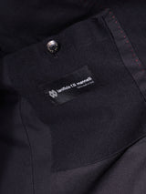 Close-up of the Casella Officers Blazer - Black by Blue de Gênes, showcasing a black fabric pocket inspired by vintage parade uniforms. A label reading “lanificio f.lli mazzinelli” and a button are positioned above the pocket, with red stitching detail visible on its right side.