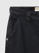Close-up of black BGpaulo Pavia V3 Chino pants by Blue de Gênes, featuring copper-colored stitching and a small shield-shaped emblem on the side pocket.