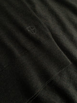 Close-up of the BGigor Polo Knit in Beech Green by Blue de Gênes, showcasing its dark, ribbed fine-gauge knit fabric with a subtle embroidered logo near the seam.
