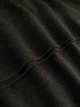 Close-up of the BGigor Polo Knit in Beech Green by Blue de Gênes, highlighting its dark, ribbed fabric with soft folds and visible texture. The fine-gauge knit pattern and subtle shadows formed by the undulating surface showcase the signature craftsmanship of this merino wool polo.