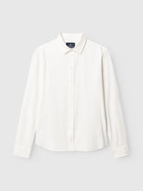 The BGenrico Tessusto Shirt - Chalk by Blue de Gênes, a long-sleeved, button-up white shirt with a collar, is crafted from honeycomb-textured cotton and finished with elegant corozo buttons, displayed on a plain light gray background.
