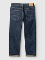 A pair of BGmarco Cast Jeans - Denim wash by Blue de Gênes, crafted from blue cotton denim and shown from the back, featuring two rear pockets, yellow stitching, and a tan leather patch on the waistband.