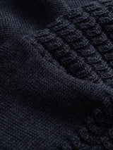 Close-up of a navy blue BGstu Rollneck Knit - Navy sweater showing smooth and textured knit stitch patterns.