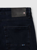Dark blue comfort stretch BGvinci Black OD V3 Jeans showing a back pocket and a black leather Blue de Gênes brand patch with a shield logo.