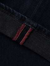 Close-up of a BGvinci Black OD V3 Jeans hem with a folded cuff showing red stitching along the selvedge seam.