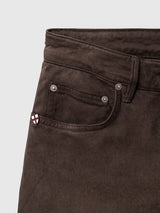 Close-up of the front pocket area of brown Blue de Gênes BGvinci Iro Pant - Hot Fudge Brown, featuring metallic rivets and a small shield-shaped logo emblem on the pocket edge.