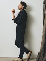 A man in a dark button-down shirt and enzyme-washed navy BGpaulo Pavia V3 Chino - Midnight Blue pants standing in profile.
