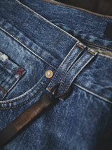Blue de Gênes BGmarco Sioux Jeans - Used in blue denim featuring a copper-tone metal rivet, a small red embroidered cross detail, and a brown leather tab attached to the belt loop.