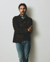 A man with arms crossed wearing a dark brown jacket and BGvinci Girisha Used Jeans - Used.