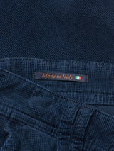Close-up of Navy Paolo Tucan Chino corduroy fabric from Blue de Gênes, featuring a Made in Italy label with an Italian flag, highlighting the garments origin and comfort stretch texture.