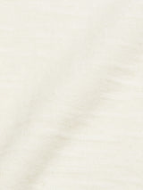 A close-up of Blue de Gênes Monte Knit - Whitecap reveals a pale cream textured fabric with subtle woven patterns and a slightly uneven surface, resembling a cotton/linen blend. The material presents a soft appearance and delicate shading.