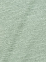 Close-up of Monte Knit - Green Bay by Blue de Gênes, crafted from a cotton/linen blend with a subtle textured weave. Gentle folds add depth and softness, while the consistent pale green hue enhances its serene allure.