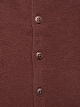 Close-up of the Blue de Gênes Zorba Knit Waistcoat in Prune, showcasing its stylish brown knit design with four vertical Corozo nut buttons. The texture reveals a fine, consistent pattern crafted from merino wool.