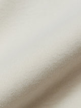 A close-up of the Nipote AW S/S Grandad - Whitecap from Blue de Gênes shows its soft, off-white cotton interlock jersey with a subtle texture and gentle folds, offering smoothness and slight fuzziness that suggest comfort and warmth.