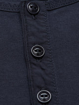 Close-up of the Nipote AW S/S Grandad T-Shirt in Dark Navy by Blue de Gênes, showcasing a collarless design with four black buttons and visible stitching on the cotton interlock jersey fabric.