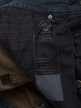 A close-up of the inside label on Vinci Haworth Jeans from Blue de Gênes reveals a regular fit with comfort stretch denim. The logo and small tab, enhanced by handmade retouching, showcase style and comfort in dark blue and brown denim.