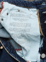 A close-up shows the pocket lining of Repi Scan Used Jeans - Mid Blue Denim by Blue de Gênes, featuring printed text with store and city names. These regular slim-fit jeans have yellow stitching, metal buttons, and are crafted from comfort stretch denim for style and flexibility.