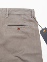 Close-up of the back of Blue de Gênes’ Paco Papago Chino in Stormy Grey, showing a single buttoned pocket. These garment-dyed trousers feature belt loops and a tag hanging on the right side.