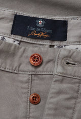 A close-up of the Stormy Grey Paco Papago Chino by Blue de Gênes highlights decorative stitching and two brown buttons with matching buttonholes, showcasing a refined style typical of similar garments.