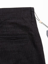 Close-up of folded navy Menzo Alvaro Chino by Blue de Gênes, showcasing their tapered leg and comforting stretch on a white background. A tag with a black string is visible on the side. These chinos feature subtle texture and classic pocket design, embodying their signature style.