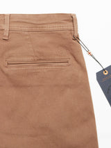 Close-up of Brownie Menzo Dobby Chino pants by Blue de Gênes, highlighting detailed back pocket stitching and a small embroidered logo. A black tag with a string on the right enhances its vintage appeal, while comfort stretch ensures ease of movement.