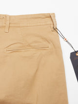 A close-up of the Menzo Dobby Chino - Khaki pants by Blue de Gênes showcases the back pocket adorned with a black tag on the belt loop. The smooth fabric with comfort stretch and precise stitching embodies a vintage look, offering minimalist elegance.